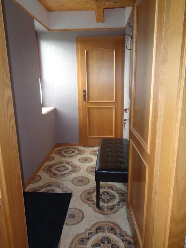 a hallway with a black stool and a door at Farma Kozí dvor Rohozná in Brezno