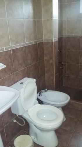 a bathroom with a white toilet and a sink at Aroma de mi Tierra in Colón