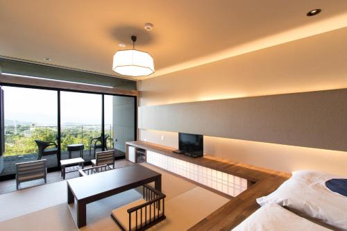 a bedroom with a bed and a table with a television at SEKIYA RESORT Terrace Midoubaru in Beppu