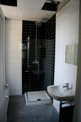 a bathroom with a shower and a sink at Hotel De Villa in Dongen