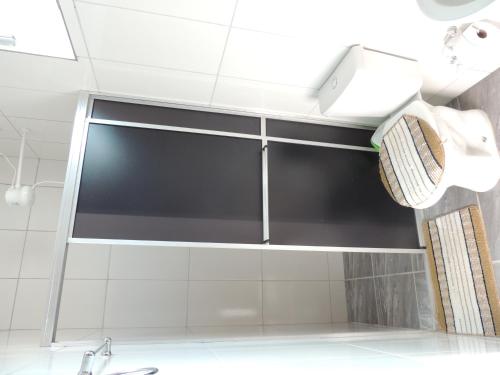 a shower stall with a glass door in a bathroom at Pousada Centaurus in Alto Paraíso de Goiás