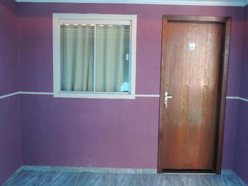 a door in a room with a purple wall at Pousada Centaurus in Alto Paraíso de Goiás