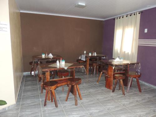 a dining room with wooden tables and chairs at Pousada Centaurus in Alto Paraíso de Goiás