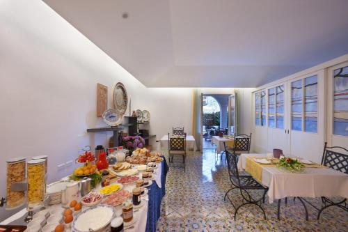 een eetkamer met tafels met eten erop bij Villa Pane Resort in Sorrento