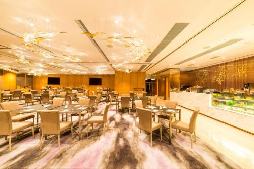a restaurant with tables and chairs in a room at Kowloon Harbourfront Hotel in Hong Kong