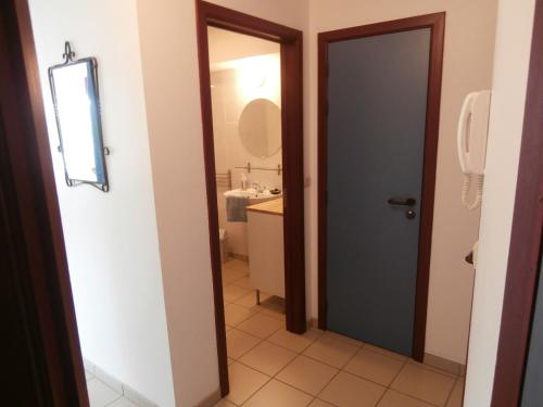 baño con puerta, lavabo y espejo en Namur Energîte, en Namur