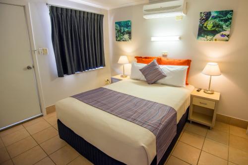 
a bedroom with a large bed and a large window at Ningaloo Reef Resort in Coral Bay
