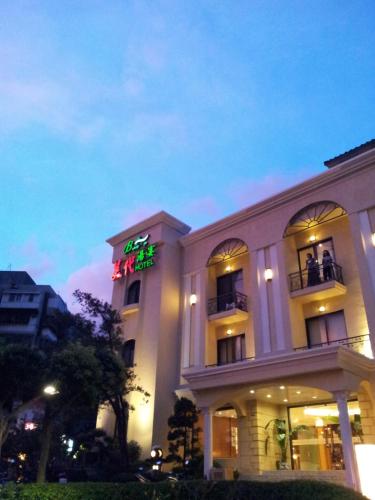 a white building with a neon sign on it at Beautyage Spring Hotel in Taipei