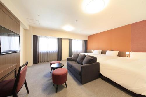 a hotel room with a bed and a couch at Richmond Hotel Kagoshima Kinseicho in Kagoshima