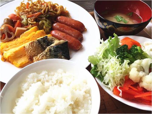 a table with two plates of food with rice and vegetables at Hotel Sun Queen in Naha