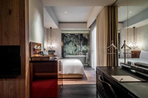 a hotel room with a bed and a bathroom at Hotel Proverbs Taipei in Taipei