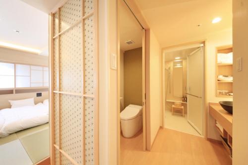 a bathroom with a bed and a toilet in a room at Richmond Hotel Kagoshima Kinseicho in Kagoshima
