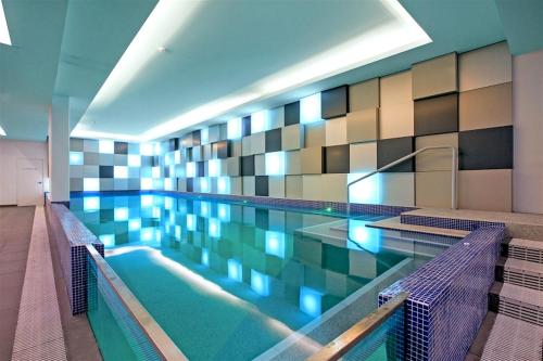 a swimming pool with two chairs in a building at Darwin City Chic@Kube Apartments in Darwin