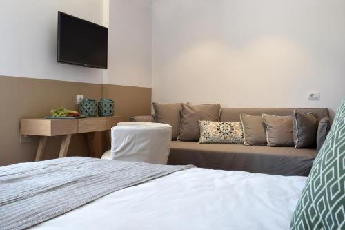 a living room with a couch and a tv at Meltemi in Skiathos Town
