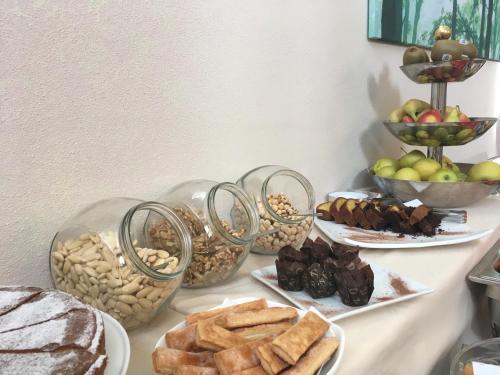 a table topped with plates of food and bowls of bread at Hotel Langhe & Monferrato in Costigliole dʼAsti