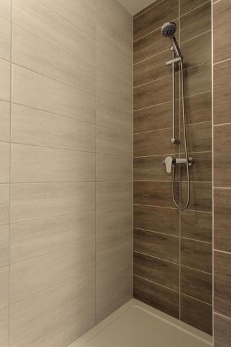 a bathroom with a shower with wooden tiles at Old Town Trio Hostel Rooms in Vilnius
