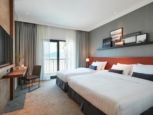 Кровать или кровати в номере The Suites Hotel Jeju