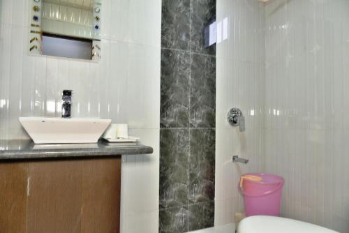 y baño con lavabo y ducha. en Hotel Akash en McLeod Ganj