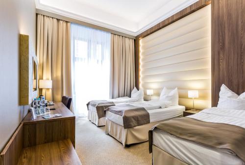 Una habitación de hotel con dos camas y una ventana. en Hotel Elektor Premium, en Cracovia