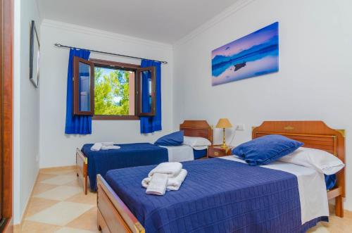 カンポスにあるFinca Rustica Arcosのベッドルーム1室(青いシーツと窓付きのベッド2台付)