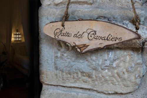 a sign on the side of a stone wall at La Torre Medioevale in Marne di Filago