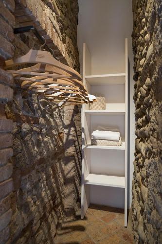 a book shelf in a room with a stone wall at La Torre Medioevale in Marne di Filago