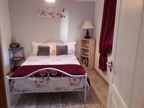 a bedroom with a white bed with a red blanket at Studio à Campagnac in Campagnac