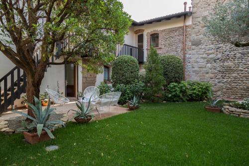 a yard with chairs and a tree and a building at La Torre Medioevale in Marne di Filago