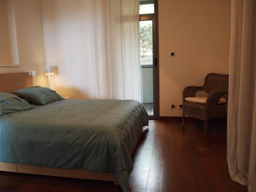 une chambre avec un lit, une chaise et une fenêtre dans l'établissement Jardins En Ville, à Bastia