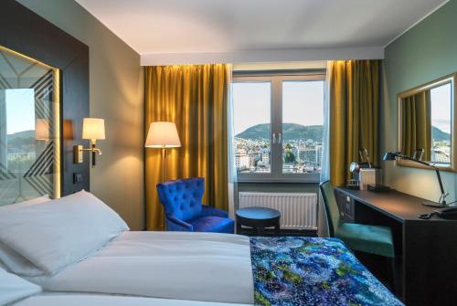 a hotel room with a bed and a desk and window at Thon Hotel Orion in Bergen