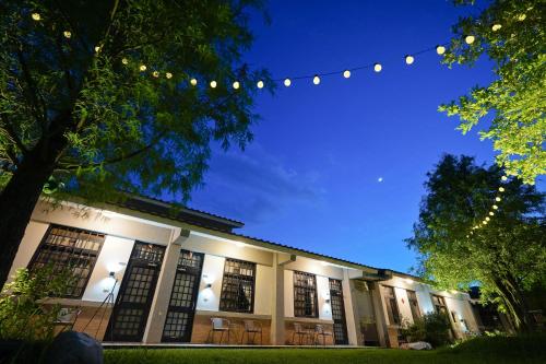 a building with chairs and lights in the night at Tobacco Village in Meinong