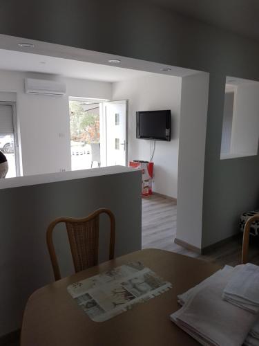 a kitchen and dining room with a table and a television at Apartments Nogic in Peroj