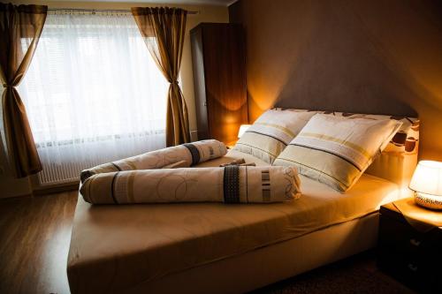 a bed with pillows on it in a room with a window at Barnabáš Rusnák Ubytovanie v súkromí in Mučín