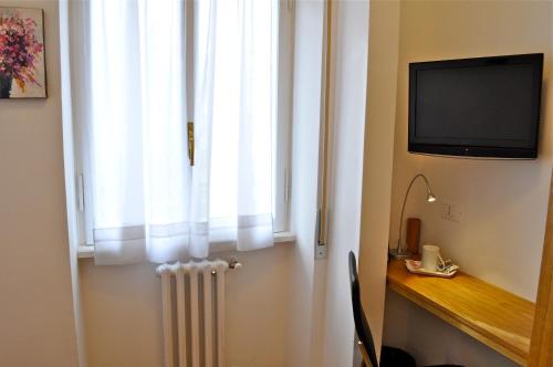 a room with a window with a radiator and a television at Aurelia Home Guest House in Rome