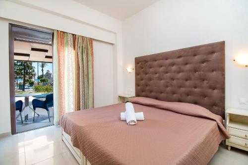 a bedroom with a large bed with a large headboard at Steve's Beach in Faliraki