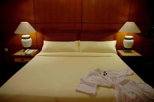 Un pat sau paturi într-o cameră la Royal Senyiur Hotel