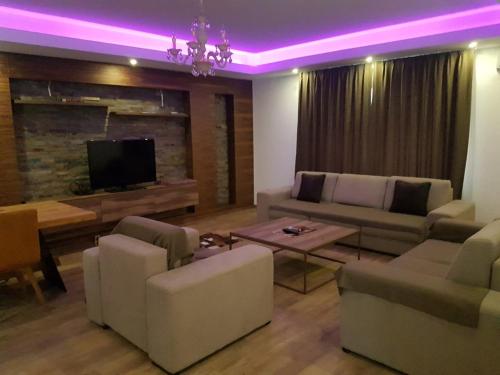 a living room with a couch and a tv and purple lighting at Sarajevo city rent in Sarajevo