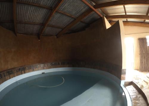 Una bañera grande en una casa con techo de madera. en Die Kuierhuis, en Ventersburg