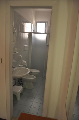 a bathroom with two toilets and a sink at Albergo Larenzia in Cattolica