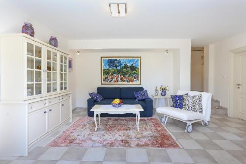 a living room with a blue couch and a table at Secret Garden Barada Beach Apartment in Trogir
