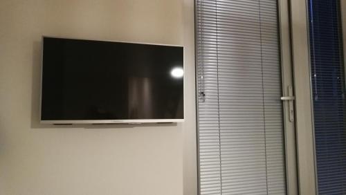 a flat screen tv hanging on a wall next to a window at Terrace Apartment Cyclades Free Parking in Amsterdam