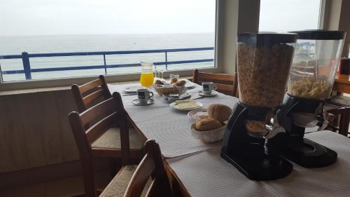 a table with a blender on it with a view of the ocean at Hotel Apartamento Praia Azul in Santa Cruz