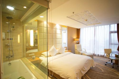 a hotel room with a bed and a bath tub at The Center Hotel Weihai in Weihai