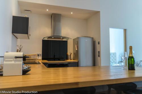 a kitchen with a large wooden table with a refrigerator at Charming Haussmannien 50m2 - city center in Rouen