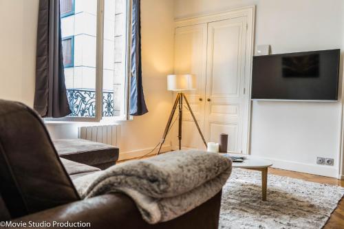 uma sala de estar com uma cadeira e uma televisão em Charming Haussmannien 50m2 - city center em Rouen