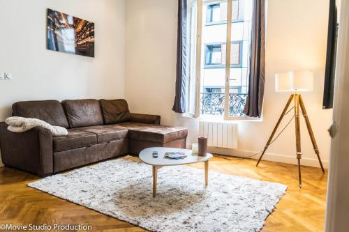 uma sala de estar com um sofá e uma mesa em Charming Haussmannien 50m2 - city center em Rouen