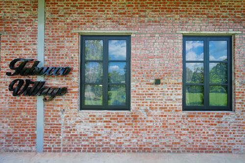 two windows on the side of a brick building at Tobacco Village in Meinong