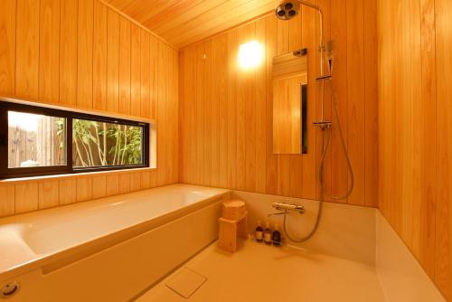 a bathroom with a bath tub and a window at Shibashi Umeyacho in Kyoto