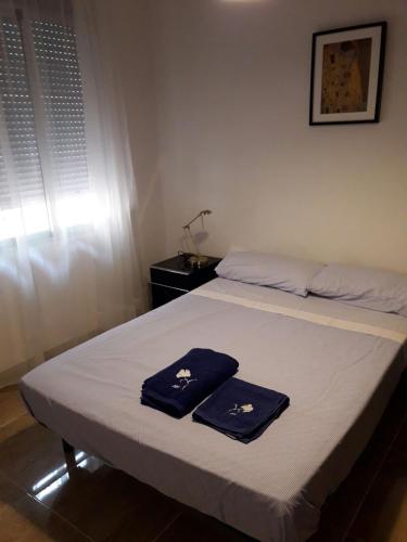 a bed with two blue towels on top of it at Apartamento Sofia in Valencia