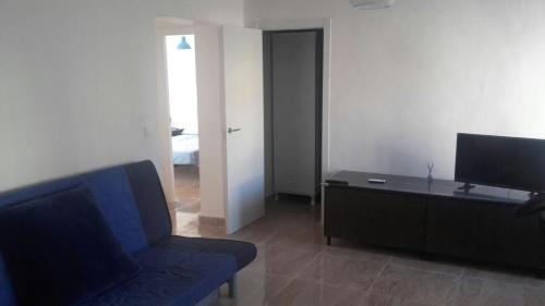 a living room with a blue couch and a television at Apartamento Sofia in Valencia